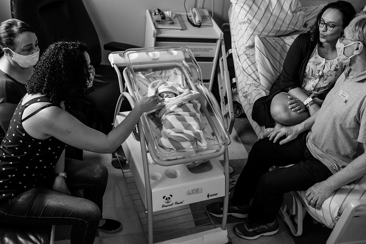 família visitando bebê em seu primeiro dia em uma foto de Adriana Costa