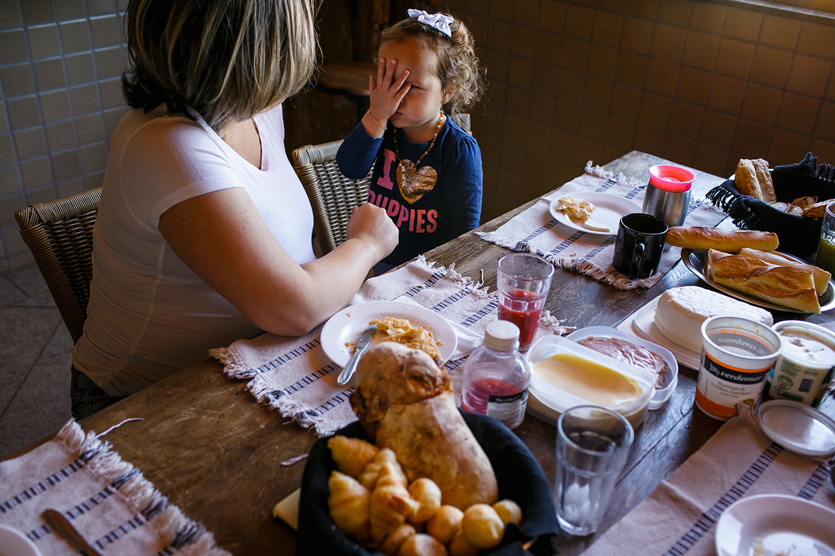 mãe gravida no café da manhã com sua outra filha