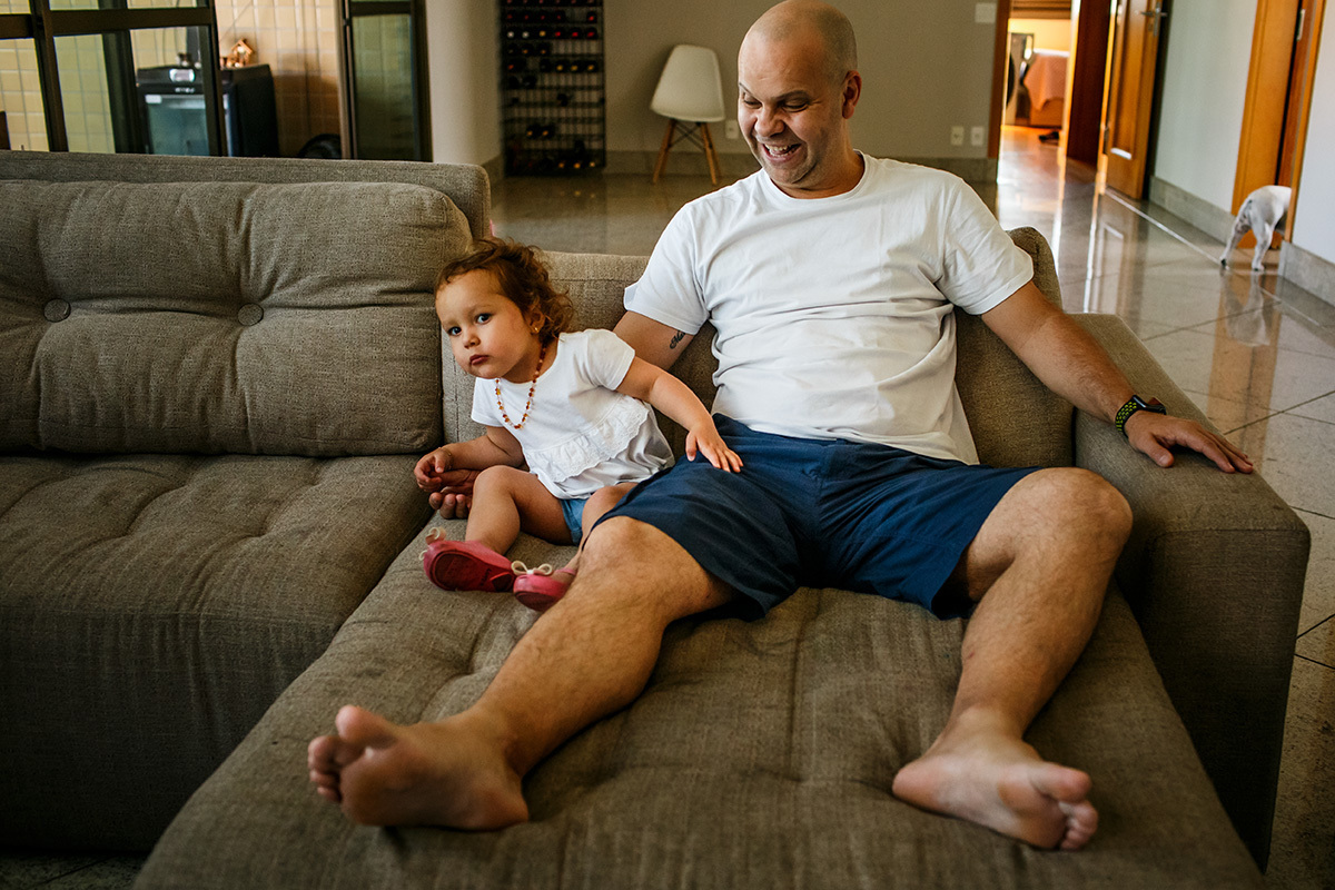 pai e filha vendo TV juntos durante a quarentena