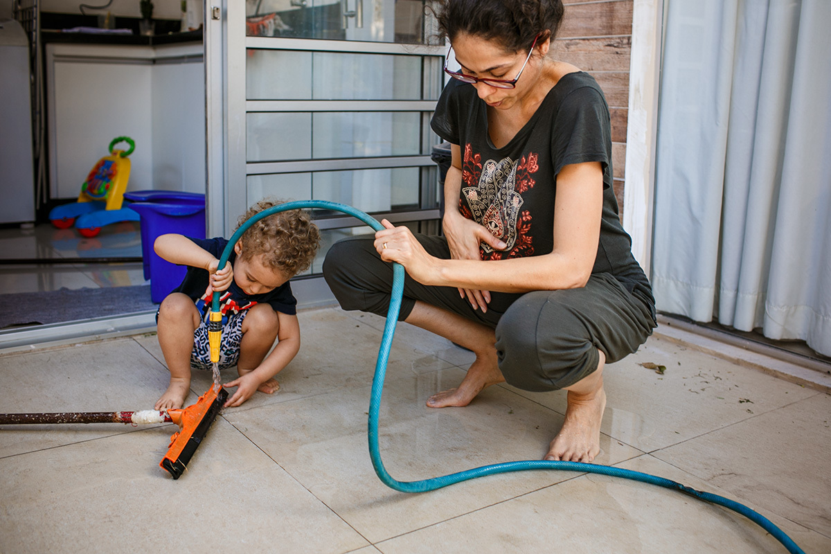mulher tendo contração enquanto lava o jardim no dia do parto