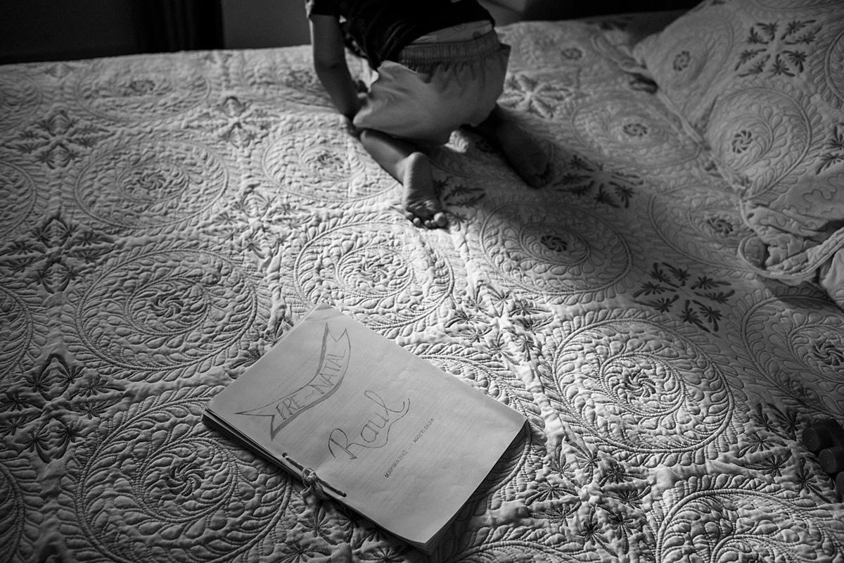 criança ao lado do plano de parto do irmão