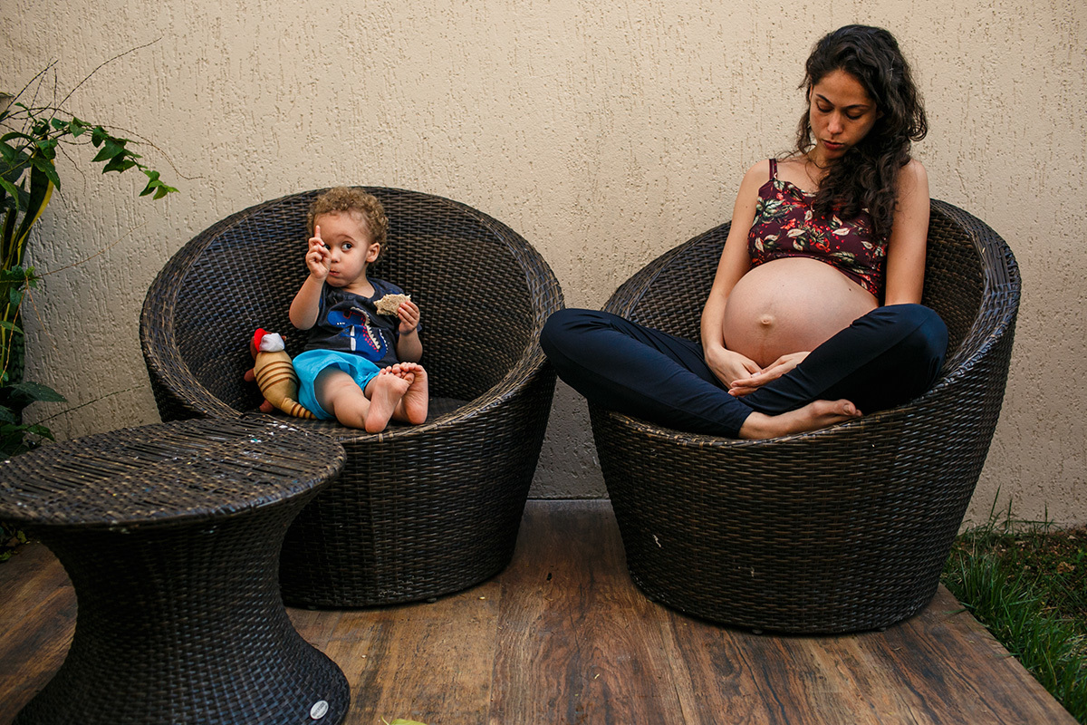 menino lanchando ao lado da mãe que está em trabalho de parto domiciliar em foto de Adriana Costa