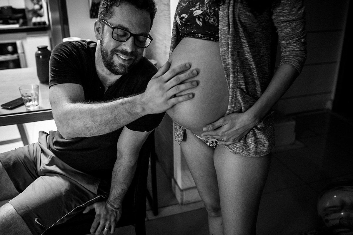 marido sentindo o bebê dentro da barriga da mulher durante um parto domiciliar assistido pela equipe do Sofia Feldman