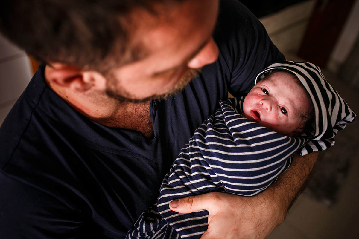 pai segurando seu bebê que acabou de nascer