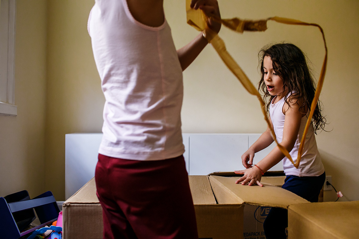 crianças desembalando as caixas da mudança 