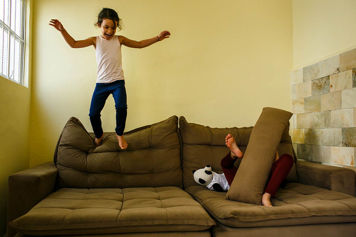 crianças divertindo no sofá em sua nova casa