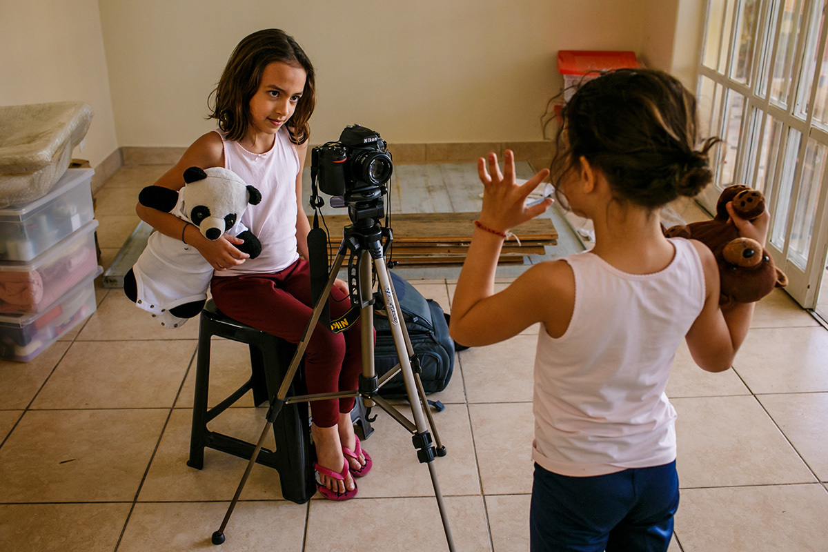 crianças brincando de filmarem uma a outra no dia de mudar de casa