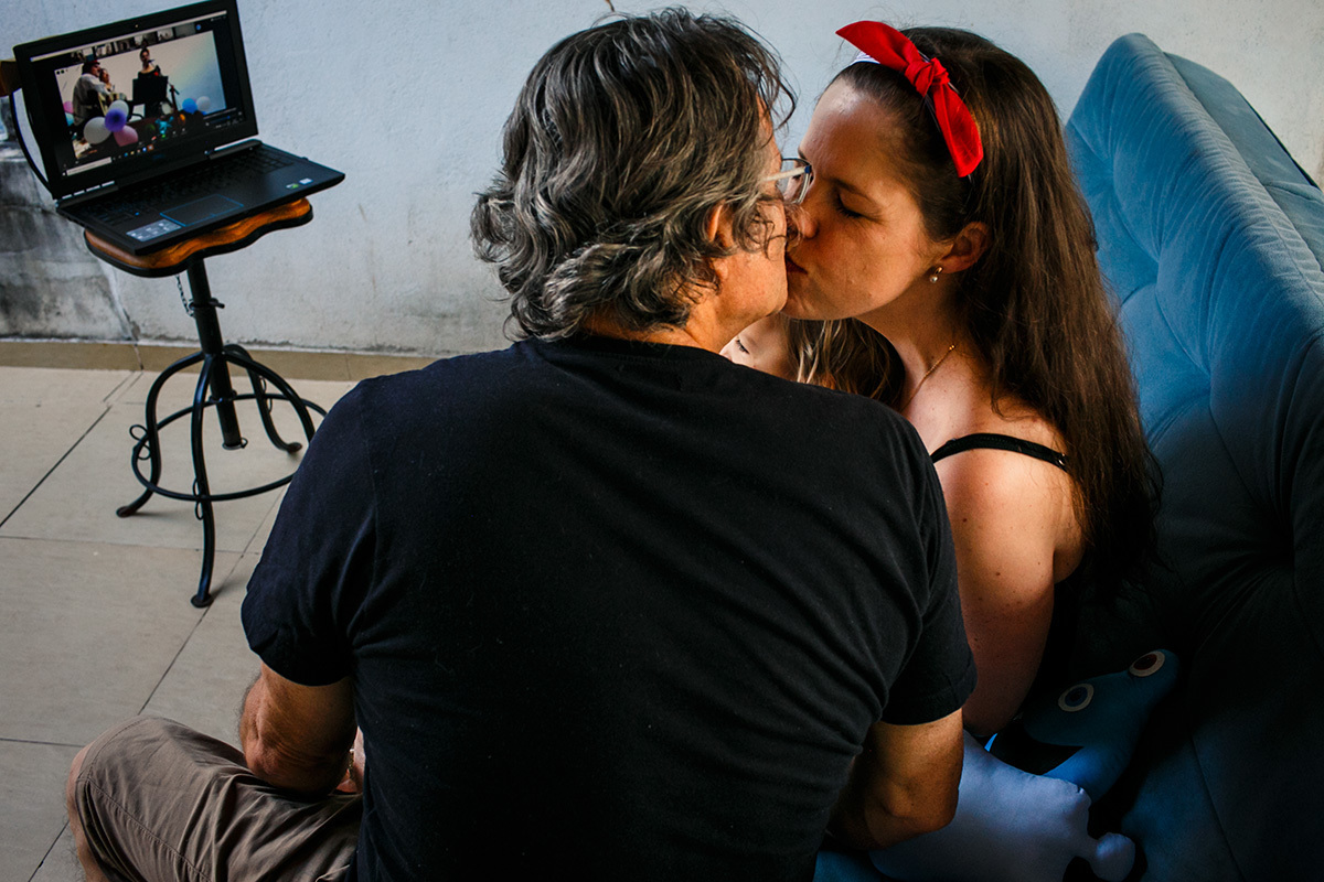 pais se beijam carinhosos durante aniversário da filha