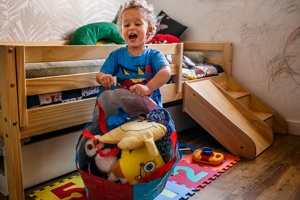 foto de Adriana Costa da criança jogando ao chão sacola de brinquedos