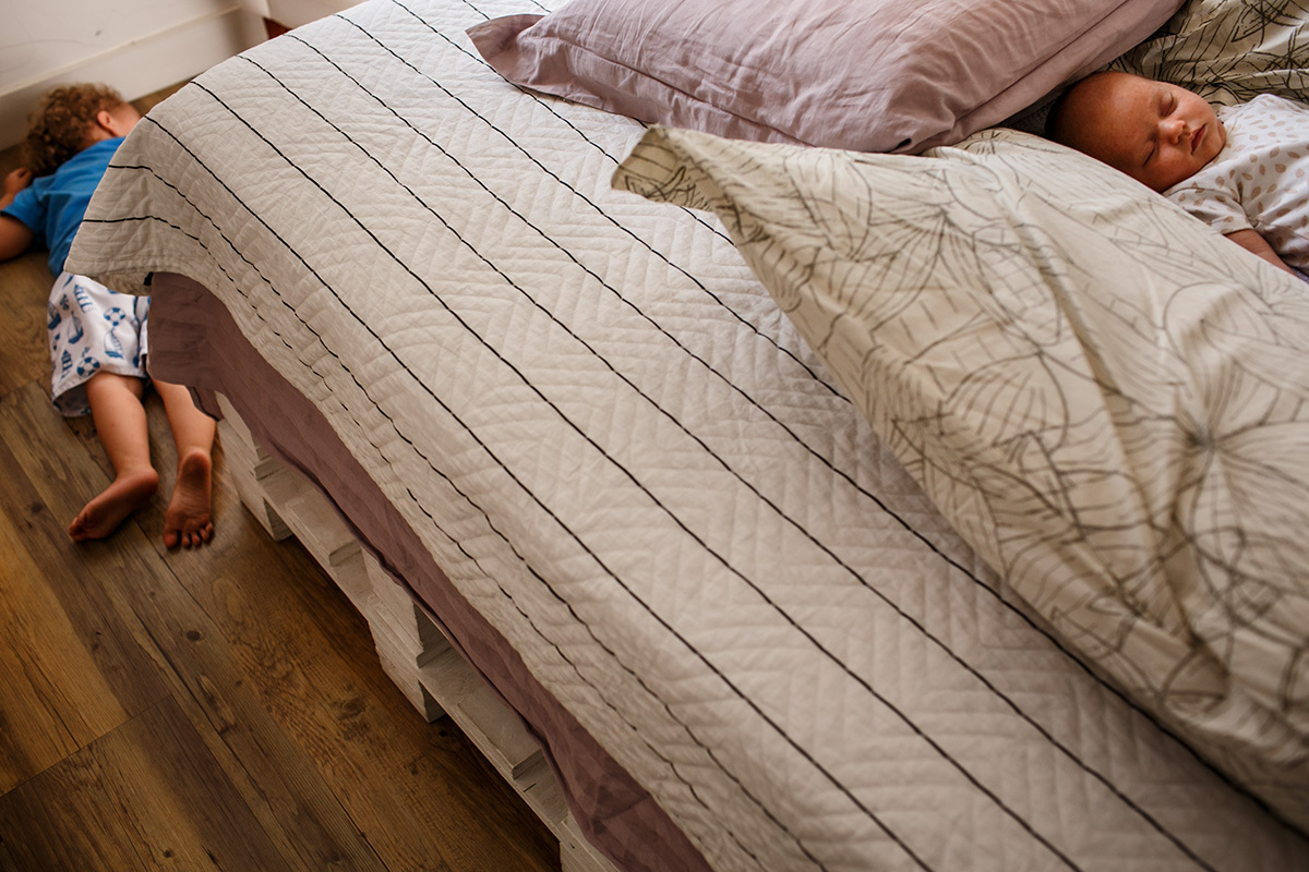 Adriana Costa documentou menino deitado ao pé da cama onde seu irmão recém-nascido dorme