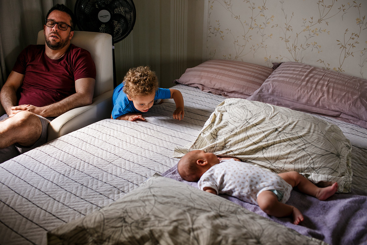 Adriana costa documentou menino subindo na cama para mexer com seu irmão recém-nascido enquanto seu pai dorme