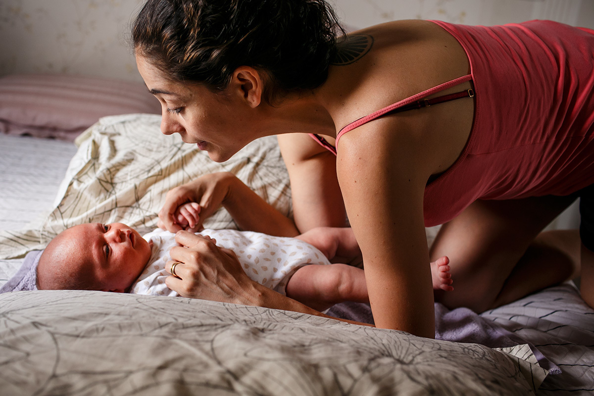 mãe fazendo carinho e conversando com seu bebê recém-nascido