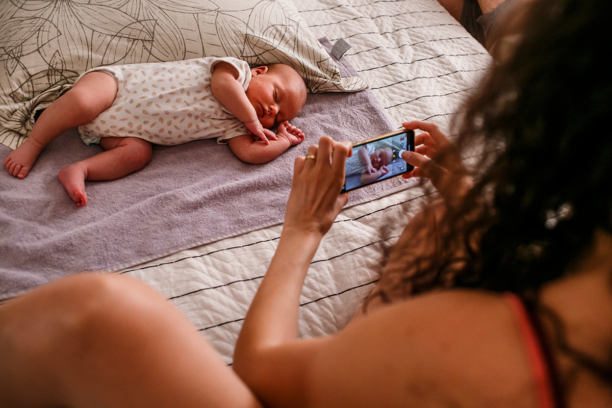 mãe tirando foto do seu bebê recém-nascido