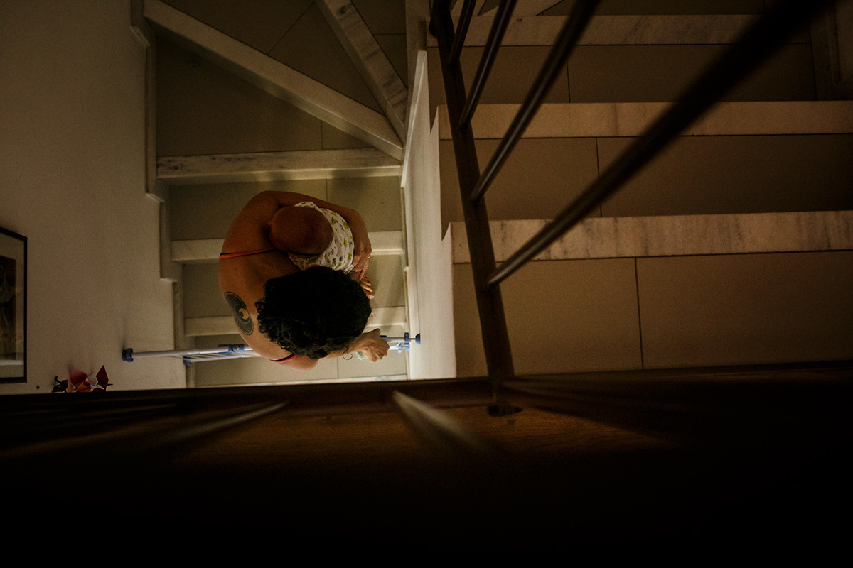 mãe e seu bebê recém-nascido descendo as escadas de casa