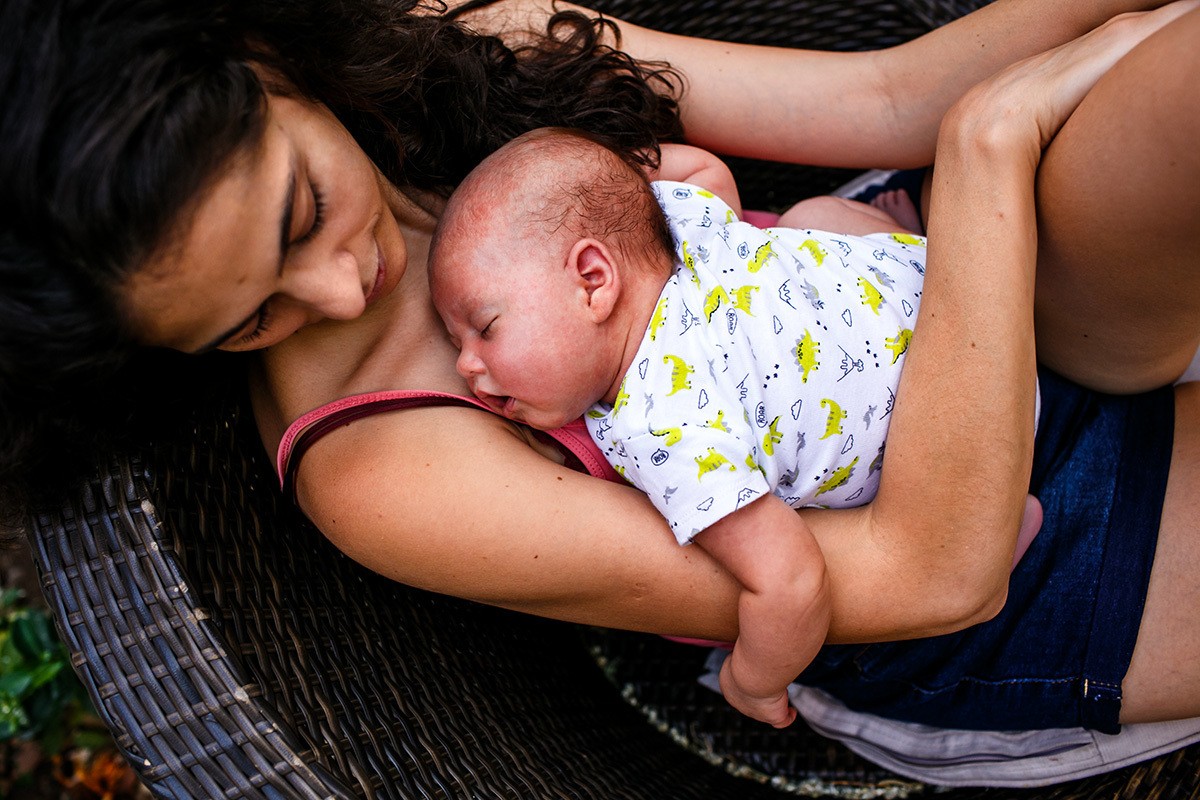 mãe observando seu bebê recém-nascido após a amamentação