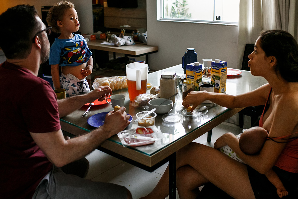 família com 2 filhos em momento carinhoso na hora do lanche da tarde