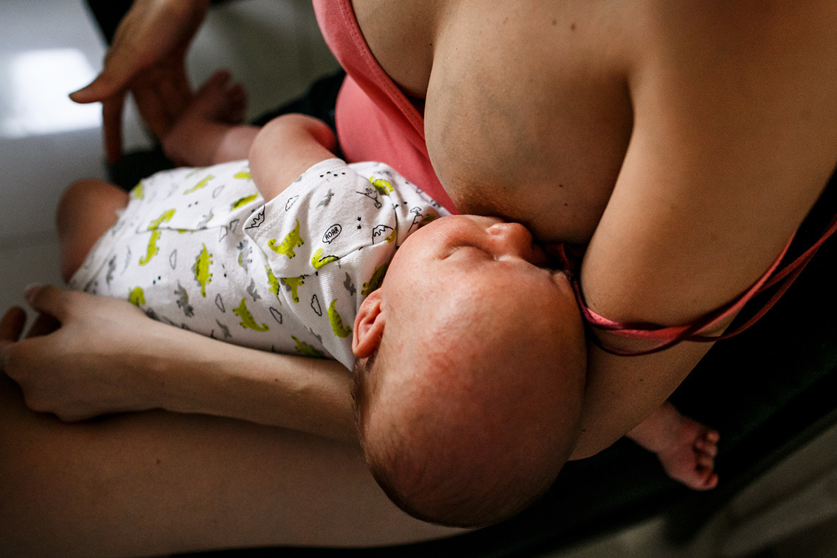 mãe amamentando seu filho recém-nascido