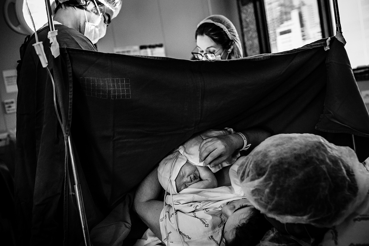 pais com seu bebê na hora de ouro após uma cesárea pelo bebê estar pélvico