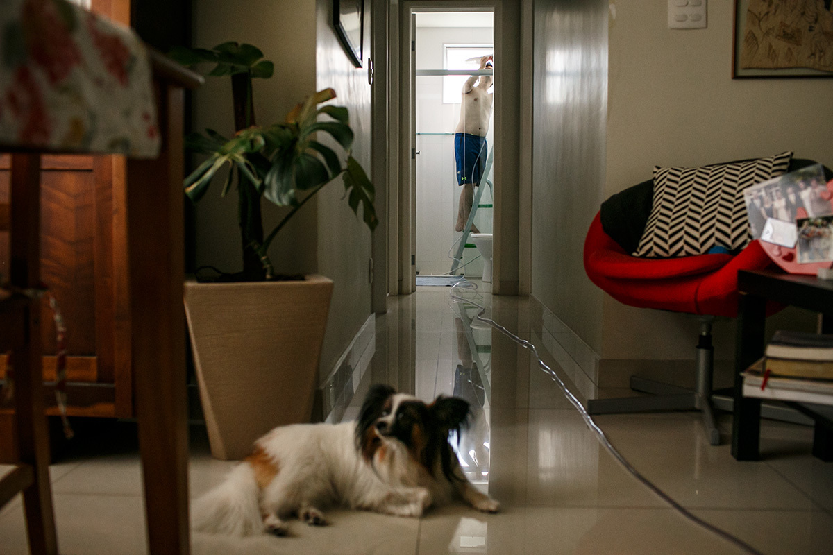 marido ligando a mangueira no chuveiro para encher a banheira do parto que irá acontecer em casa