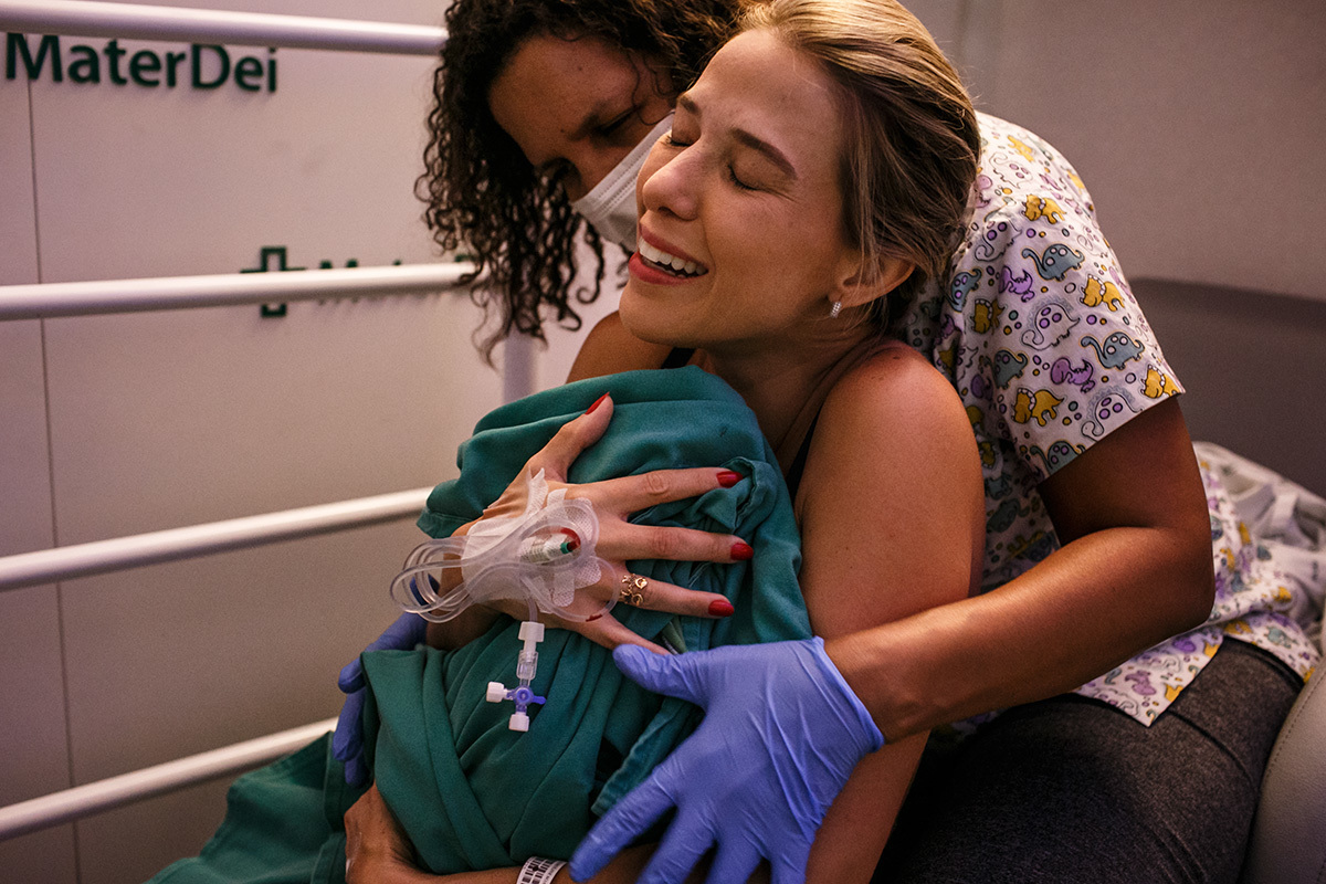 Foto de Adriana Costa da mulher abraçando emocionada o seu filho que acabou de nascer