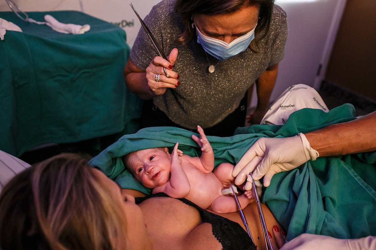 Avó corta o umbigo de seu neto após o nascimento