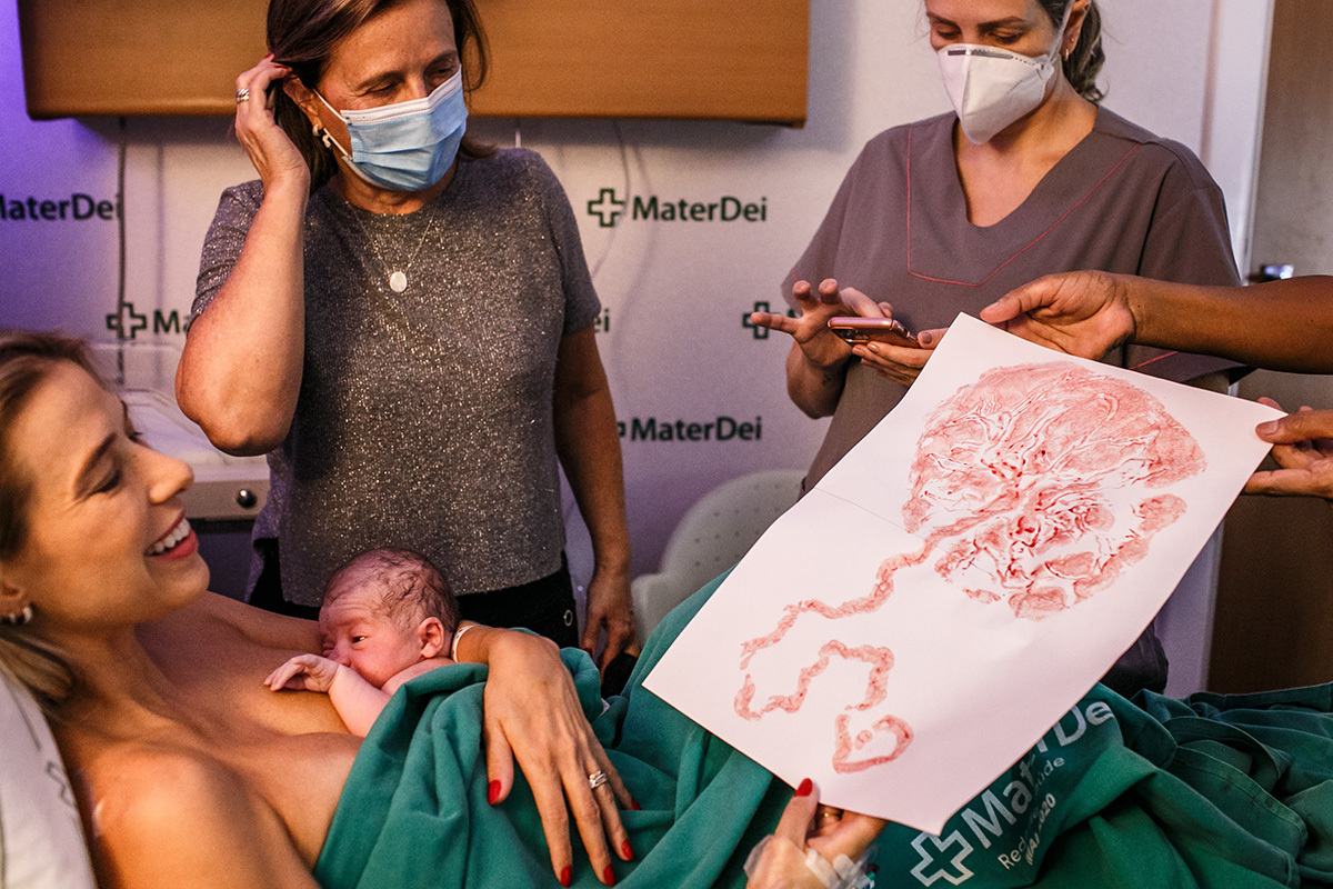 doula mostra o carimbo que ela fez da placenta para a mulher