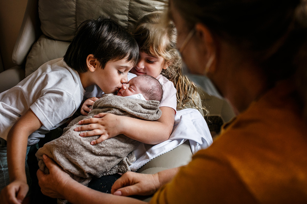 menino beija seu irmão que acabou de nascer