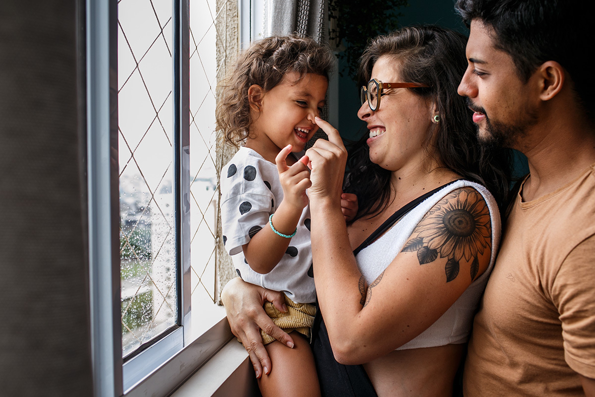 pais grávidos em momento de carinho com sua primogênita