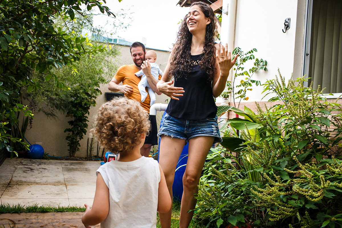 pais dançando com os filhos pequenos no quintal