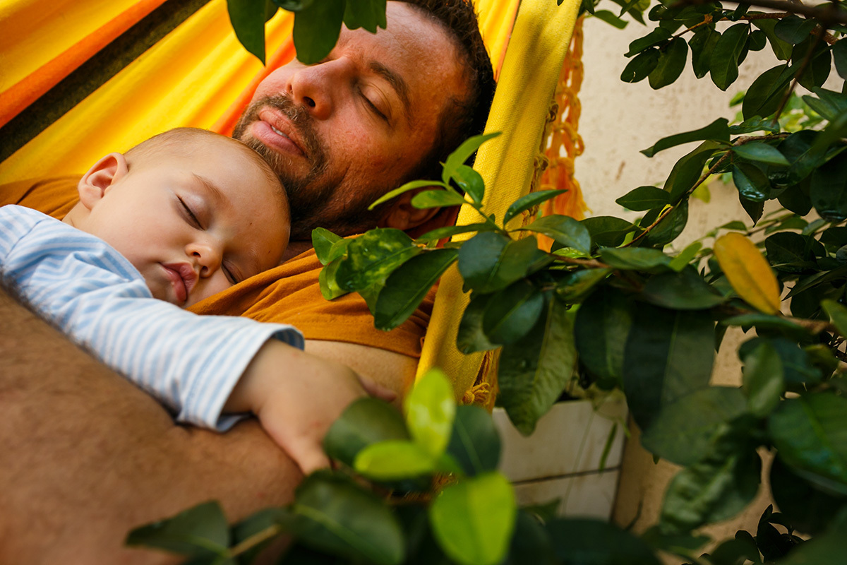 pai dormindo com seu bebê na rede