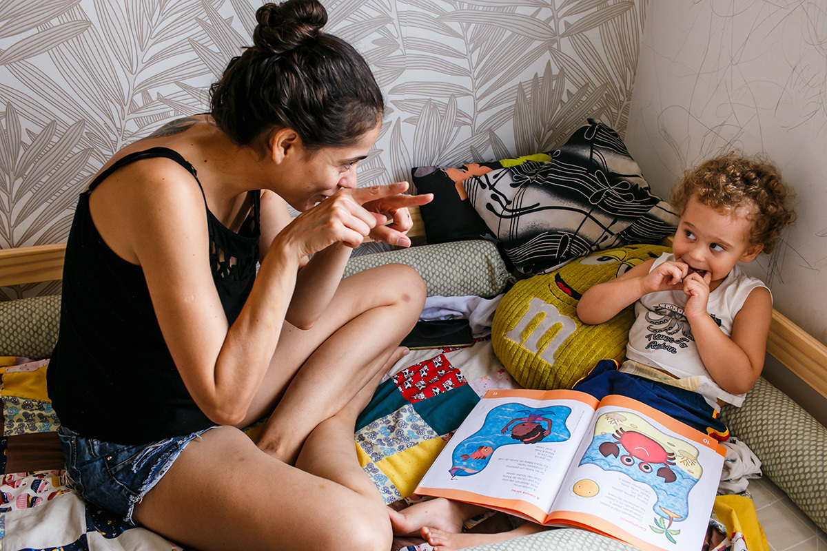 menino se diverte com a contação de estórias de sua mãe