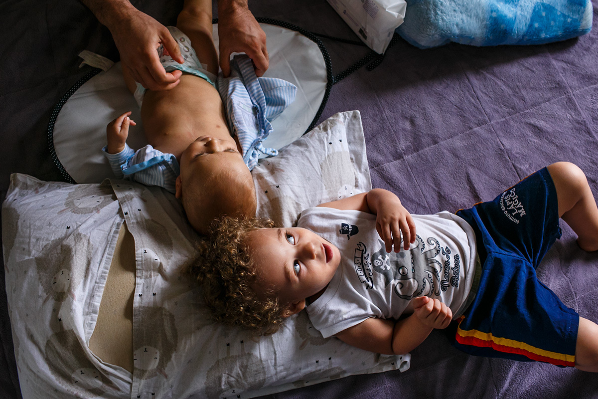 pai trocando a fralda de seu filho