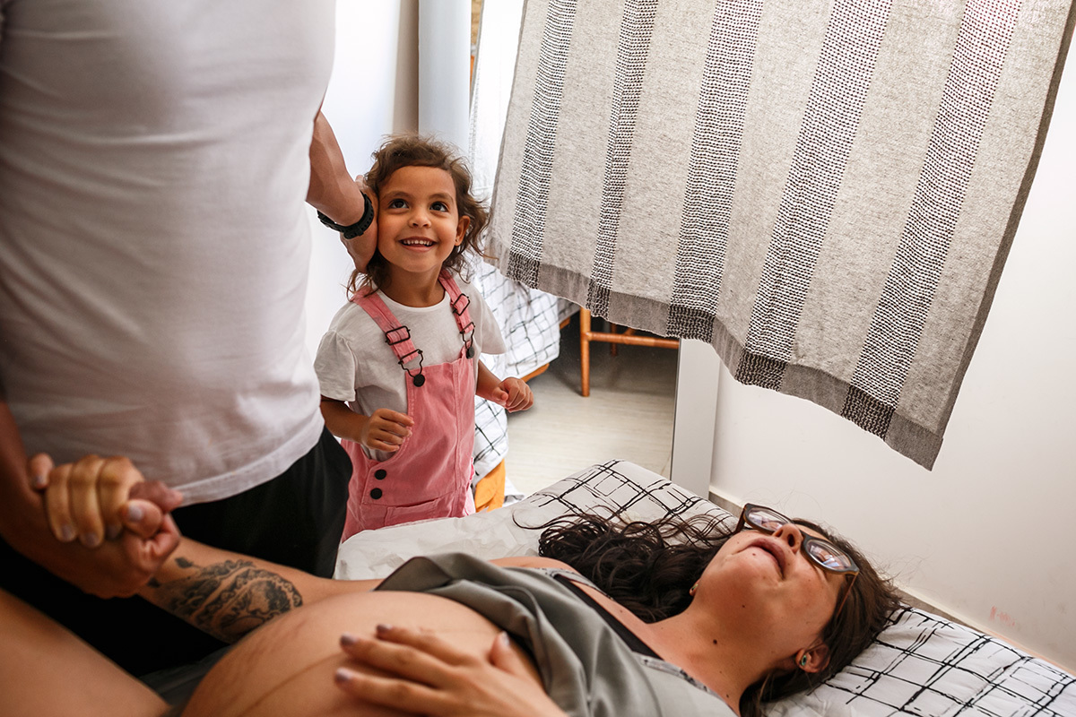 Adriana Costa fotografou o cuidado da filha e do marido com a parturiente em trabalho de parto domiciliar