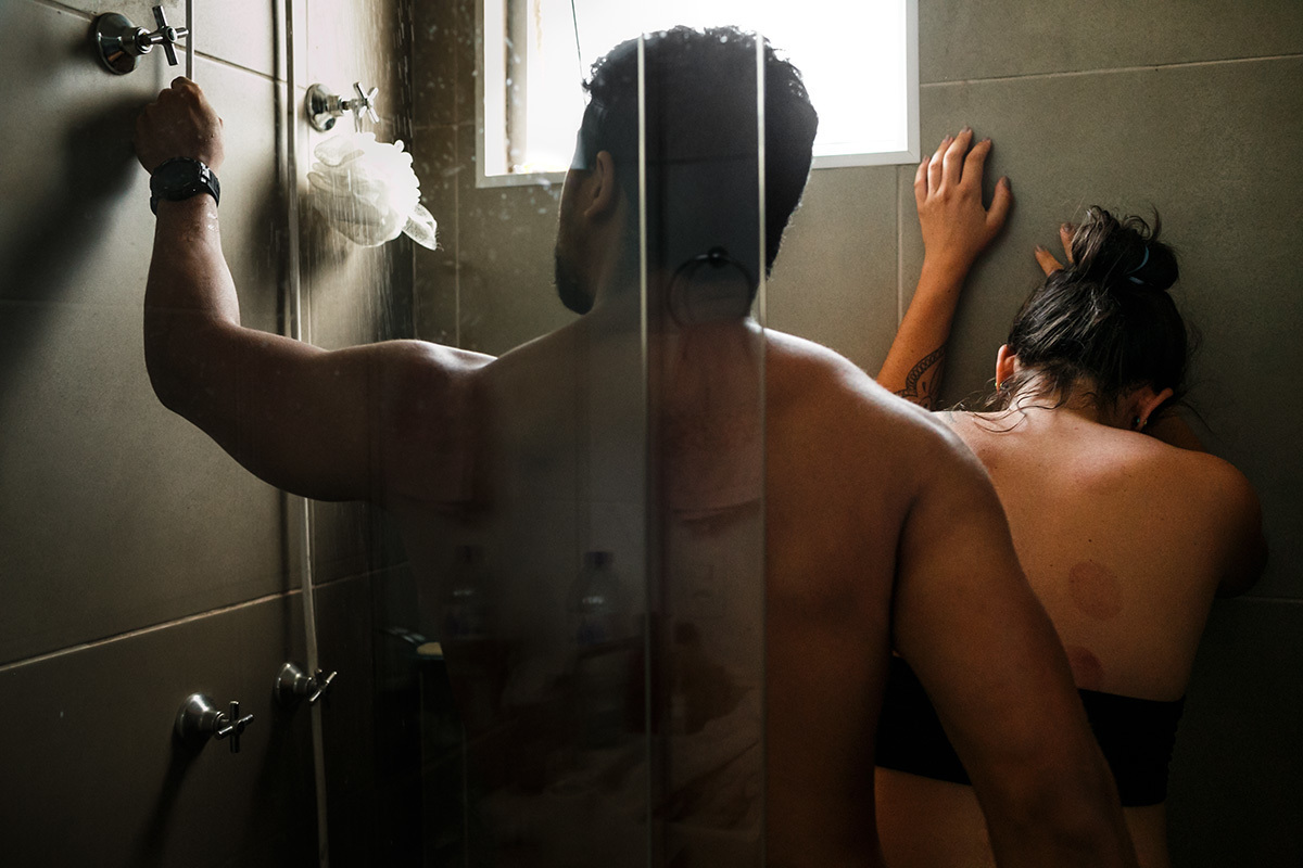 casal no chuveiro para aliviar as dores das contrações do parto