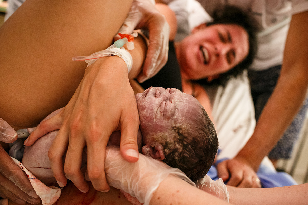 foto de Adriana Costa da própria mãe emocionada pegando o seu bebê ao nascer durante um parto natural