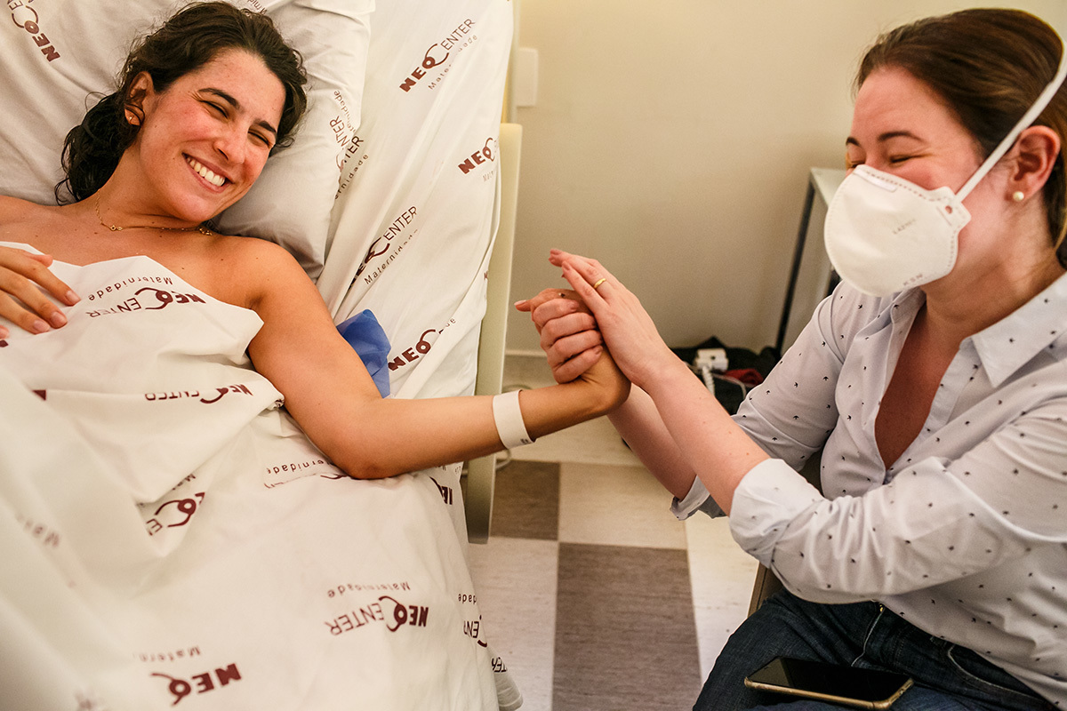 médica e mulher que acabou de parir comemoram o parto natural que correu bem