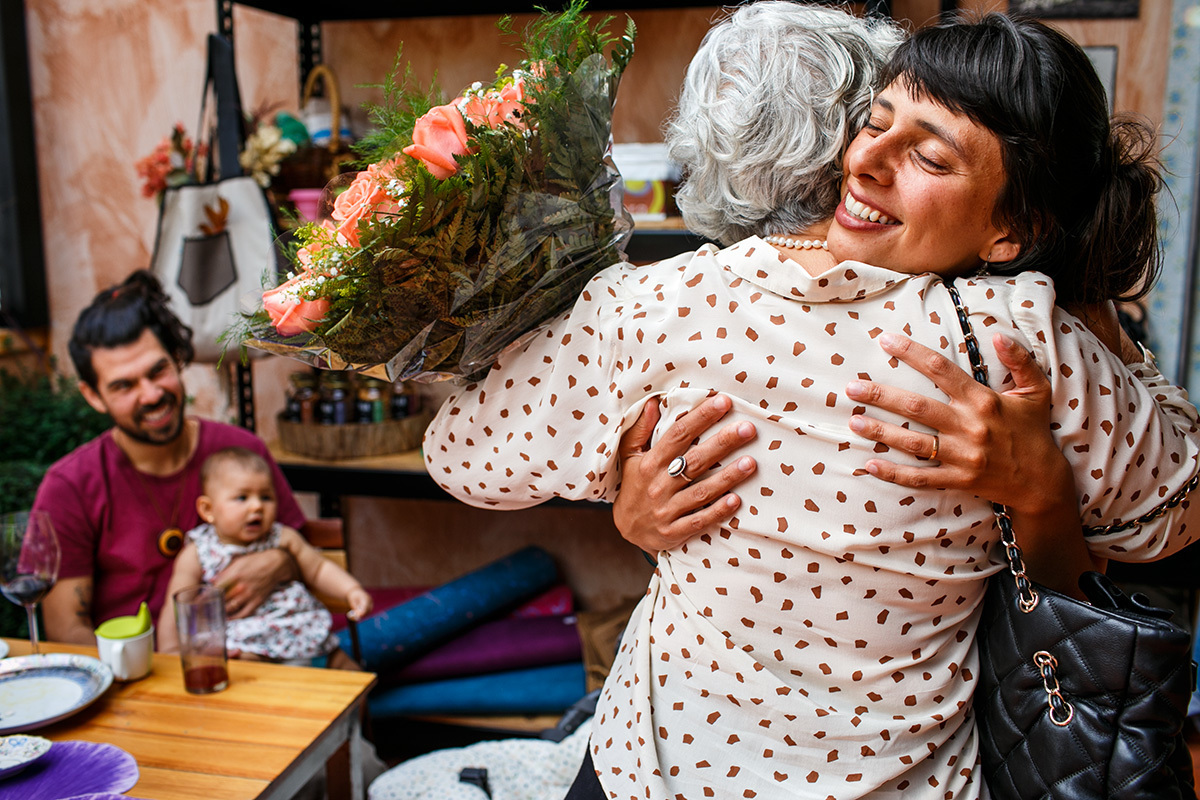 mãe entrega o buquê para filha que comemora o casamento civil após 5 anos de união e 2 filhos