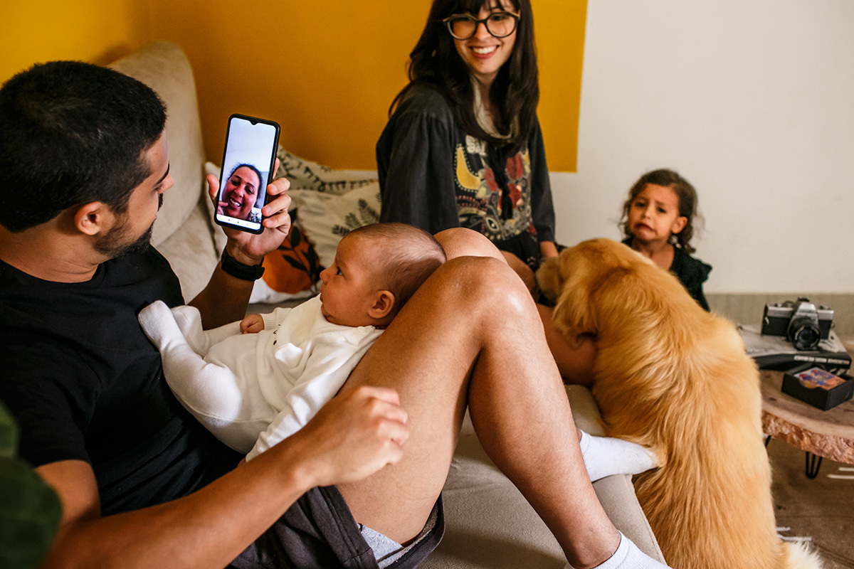 família com bebê recém-nascido conversa com a avô pelo celular devido a pandemia