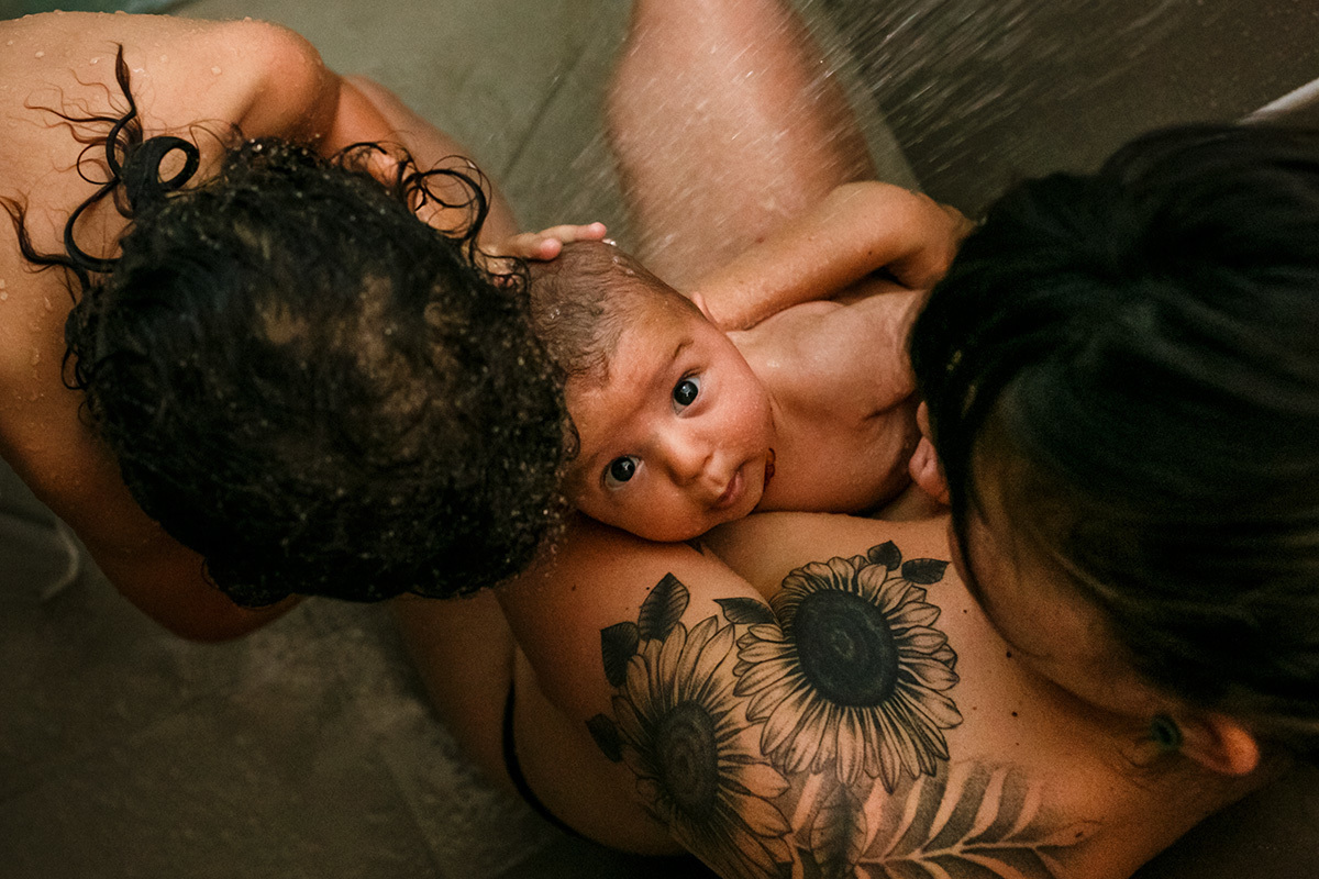 mãe e seus 2 filhos tomando banho de chuveiro