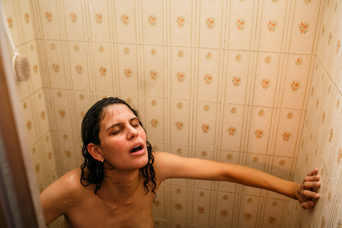 mulher no chuveiro em trabalho de parto domiciliar em foto de Adriana Costa