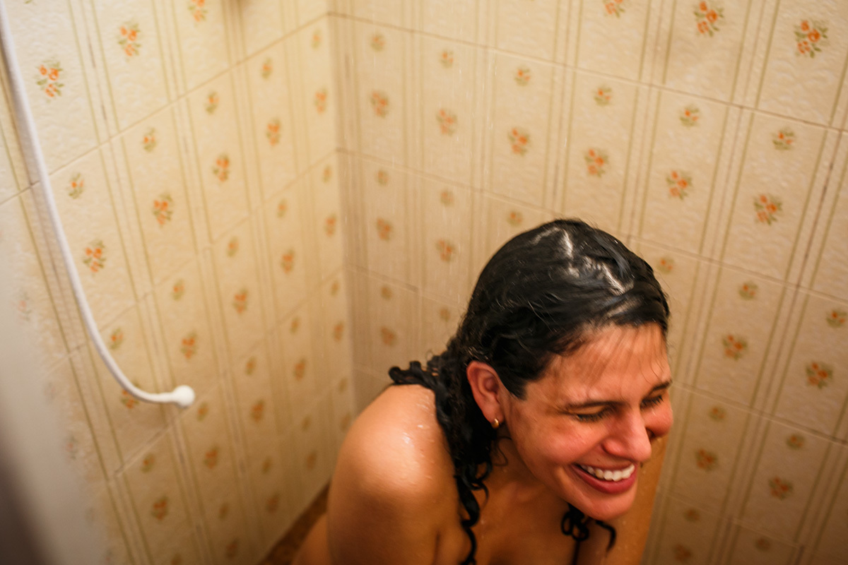 grávida sorri feliz após a contração durante seu trabalho de parto em foto de Adriana Costa