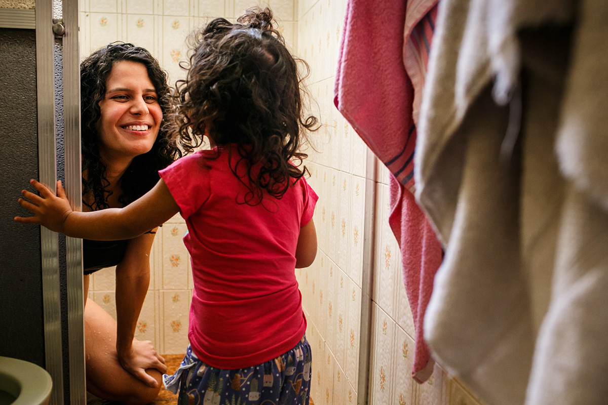 mulher em trabalho de parto brinca com sua filha de 2 anos durante seu parto domiciliar