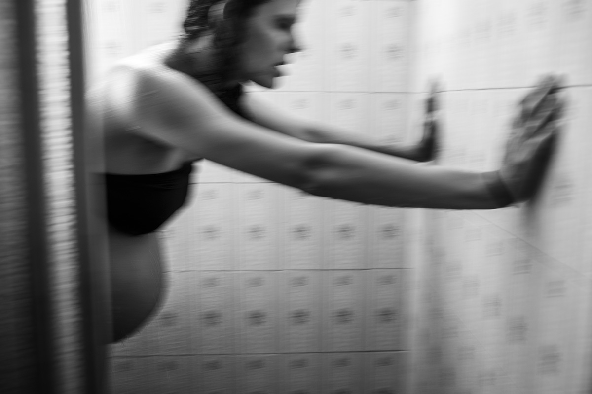 grávida se movimentando no chuveiro para aliviar as dores das contrações do trabalho de parto em foto de Adriana Costa