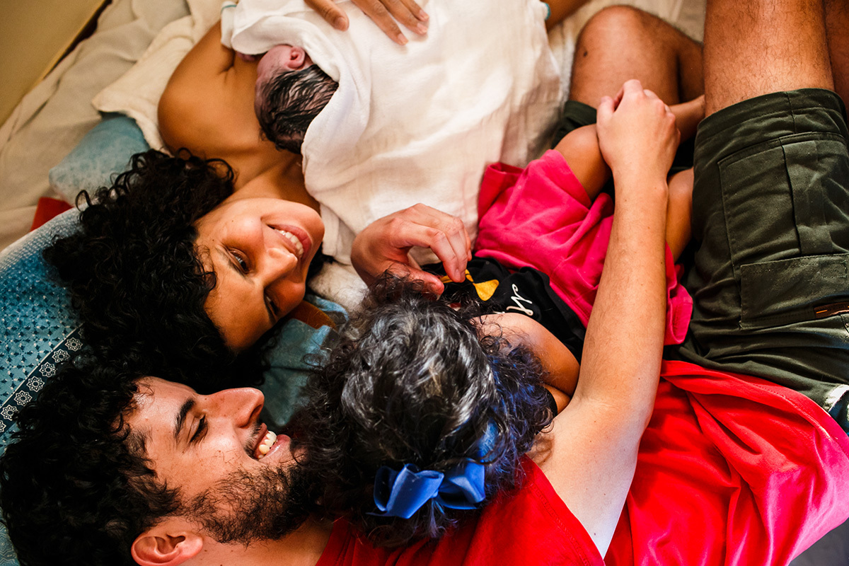 família celebra o filho que acabou de nascer em um parto domiciliar