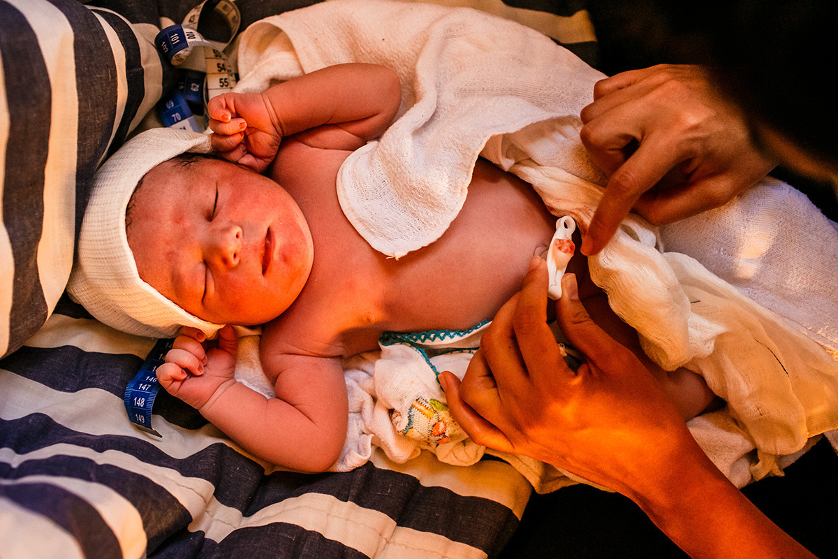bebê sendo cuidado pela equipe Bom Parto após seu nascimento domiciliar em foto de Adriana Costa