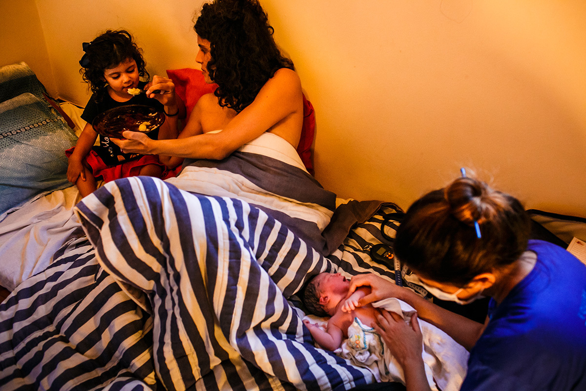 enquanto a Equipe Bom Parto examina o bebê, mãe cuida da filha mais velha