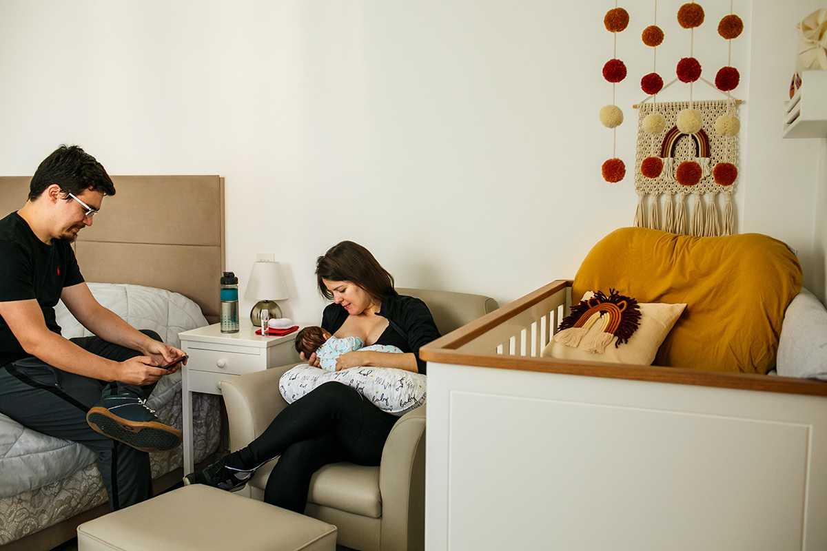 casal juntos na hora de amamentação em foto de Adriana Costa