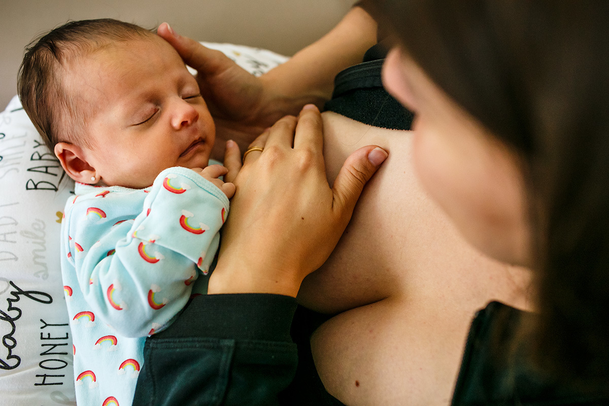 Adriana Costa fotografou bebê recém-nascido relaxado no colo da mãe após amamentação