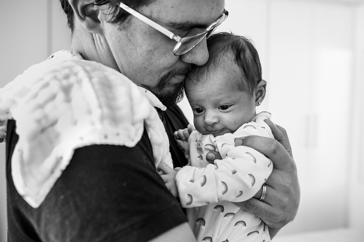 pai carrega a filha no colo para arrotar