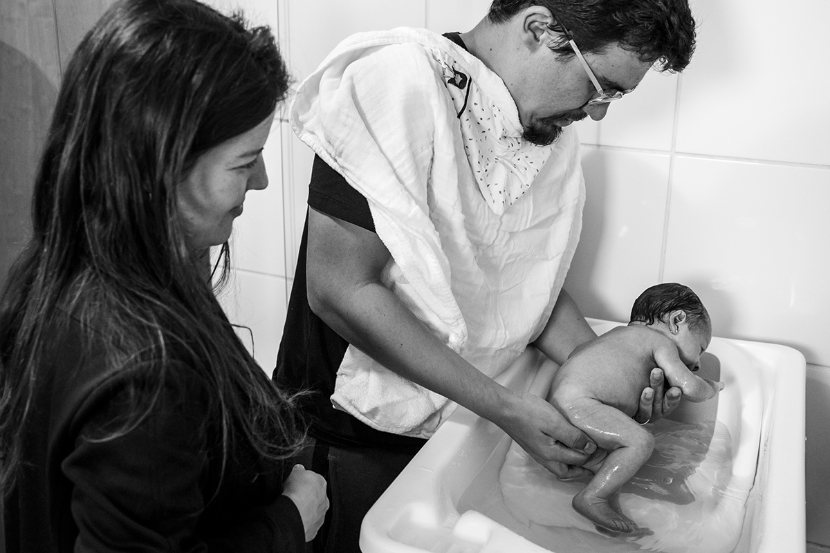 pais dão banho em sua bebê recém-nascida